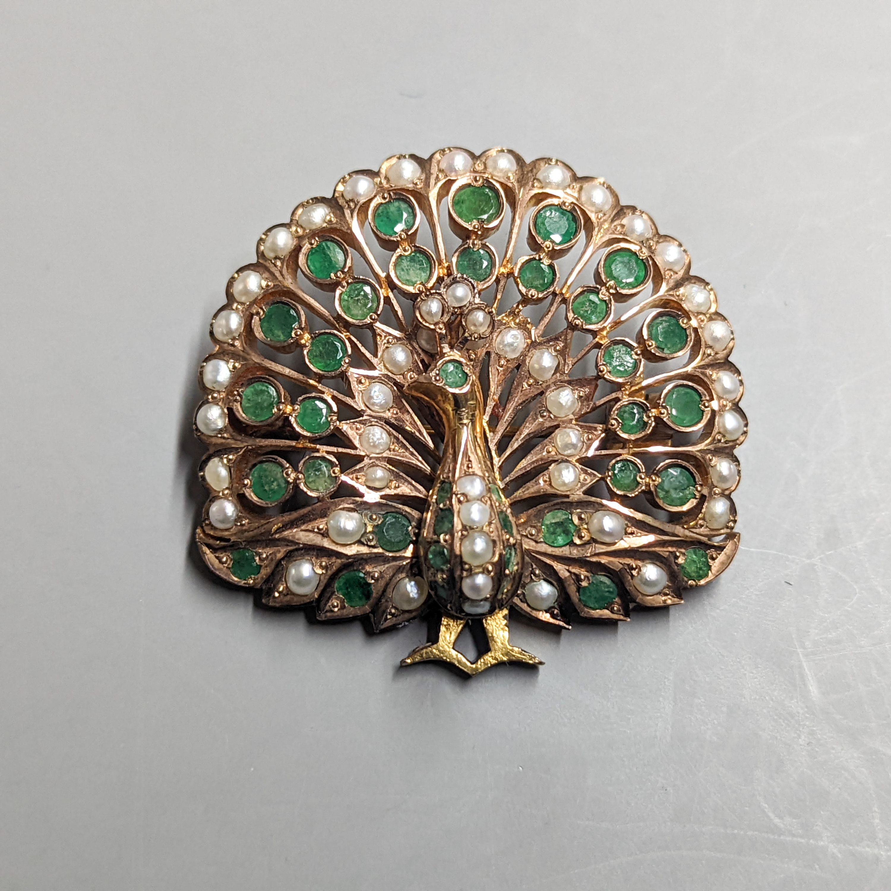 An Indian? gilt metal emerald and seed pearl cluster set peacock pendant brooch, height 45mm.